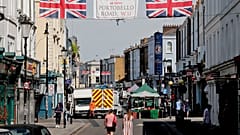 People walk along Portobello Road Market in London, Wednesday, May 27, 2020.