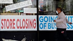 A man looks at signs of a closed store due to COVID-19 in Niles, Ill., Thursday, May 21, 2020. 
