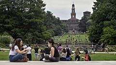People enjoy sitting in a park in central Milan, northern Italy