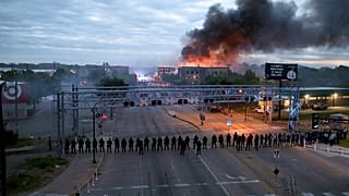 Militares e polícia patrulham as ruas de Minneapolis enquanto vários edifícios ardem, incendiados durante os protestos pela morte de George Floyd