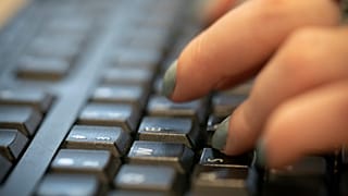 A woman types on a keyboard in New York