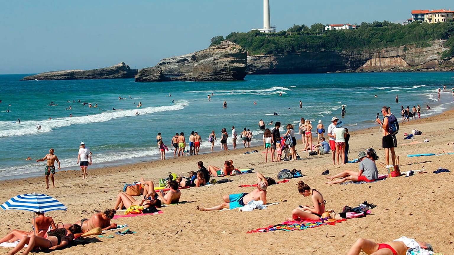 People sit on Biarritz beach, southwestern France, Saturday, May 30, 2020. 