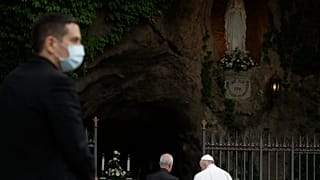 A priest wears face mask to prevent the spread of COVID-19, as Pope Francis prays during a rosary in Vatican gardens Saturday, May 30, 2020.