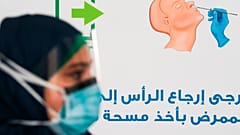 A technician prepares to take another nasal swab sample at a new coronavirus detection test at a drive-thru testing facility in Abu Dhabi