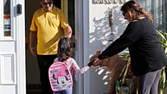 A mother drops off her daughter at the Little Darling home-based Childcare after nurseries and primary schools partly open in England
