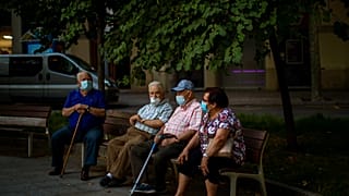 Un grupo de ancianos sentados con mascarillas en Barcelona, España