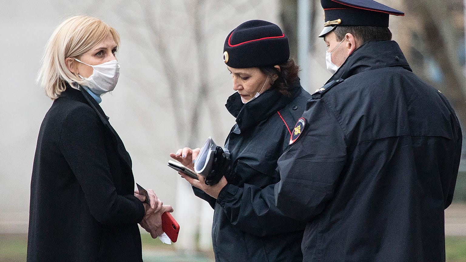 In this April 8, 2020, file photo, police officers check documents of a woman to ensure she is complying with a self-isolation regime due to coronavirus in Moscow, Russia