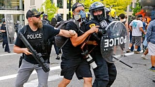Agentes de policía empujan a un fotógrafo el sábado en Salt Lake City