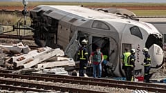 Bomberos y guardias civiles en la escena de un accidente después de que un tren de pasajeros de alta velocidad chocara con un coche en La Hiniesta