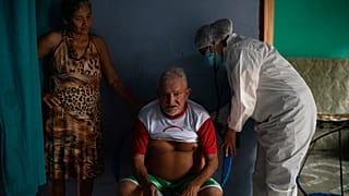 Francisco de Oliveira, 77 anos, respira fundo enquanto é examinado por um médico em Manacapuru, Amazonas
