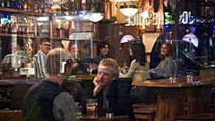People sit in a bar in Stockholm, Sweden, Wednesday, March 25, 2020. (AP Photo/David Keyton, File)