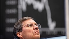 A broker watches screens at the DAX stock exchange in Frankfurt.