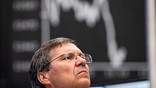A broker watches screens at the DAX stock exchange in Frankfurt.