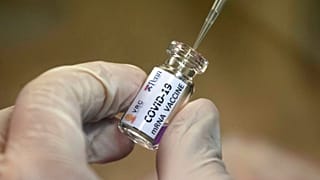 A lab technician extracts a portion of a COVID-19 vaccine candidate at the Chula Vaccine Research Center, run by Chulalongkorn University in Bangkok, Thailand, May 25, 2020