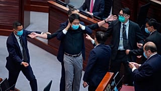Hui Chi-fung, diputado del bloque prodemocracia, es advertido por la seguridad en la cámara principal del Consejo Legislativo en Hong Kong, el jueves 4 de junio de 2020.