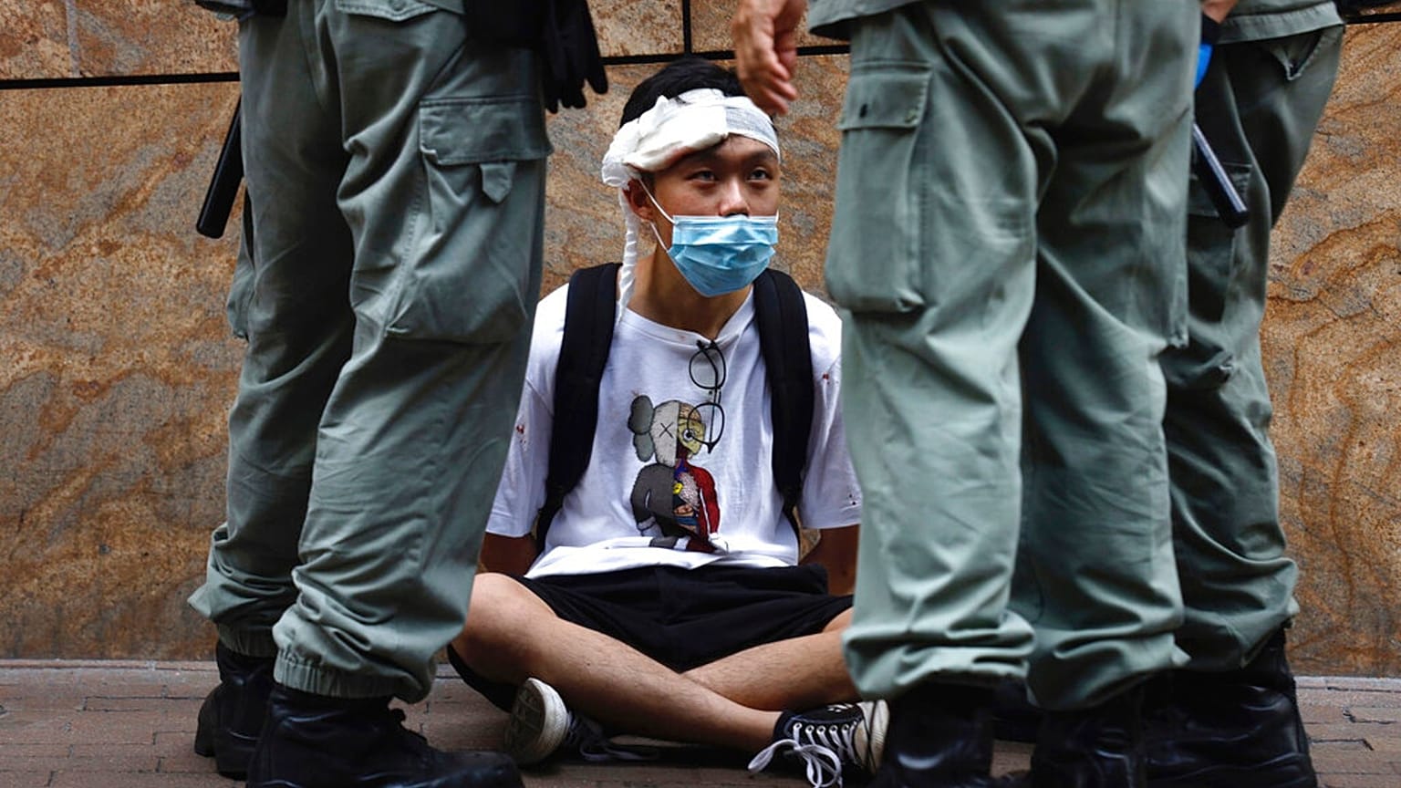 Riot police guard a protester as a second reading of a controversial national anthem law takes place in Hong Kong, Wednesday, May 27, 2020. 