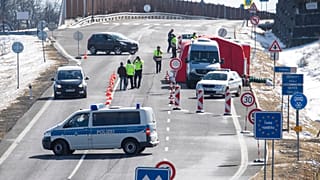 Czech policemen are standing on a street at the Czech border for entry control near Zinnwald, Germany.