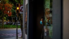Sunday, May 31, 2020 photo, a waiter wearing a face mask waits for customers in a terrace bar in Barcelona.
