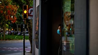 Sunday, May 31, 2020 photo, a waiter wearing a face mask waits for customers in a terrace bar in Barcelona.