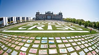 Activists of the Fridays for Future movement place protest posters for climate protection in front the German parliament in Berlin
