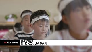 Los niños en clase con visera de plástico