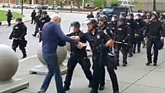 A Buffalo police officer shoves a man who walked up to police Thursday, June 4, 2020, in Buffalo, N.Y.