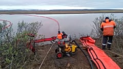 Rescuers work to prevent the spread of an oil spill outside Norilsk
