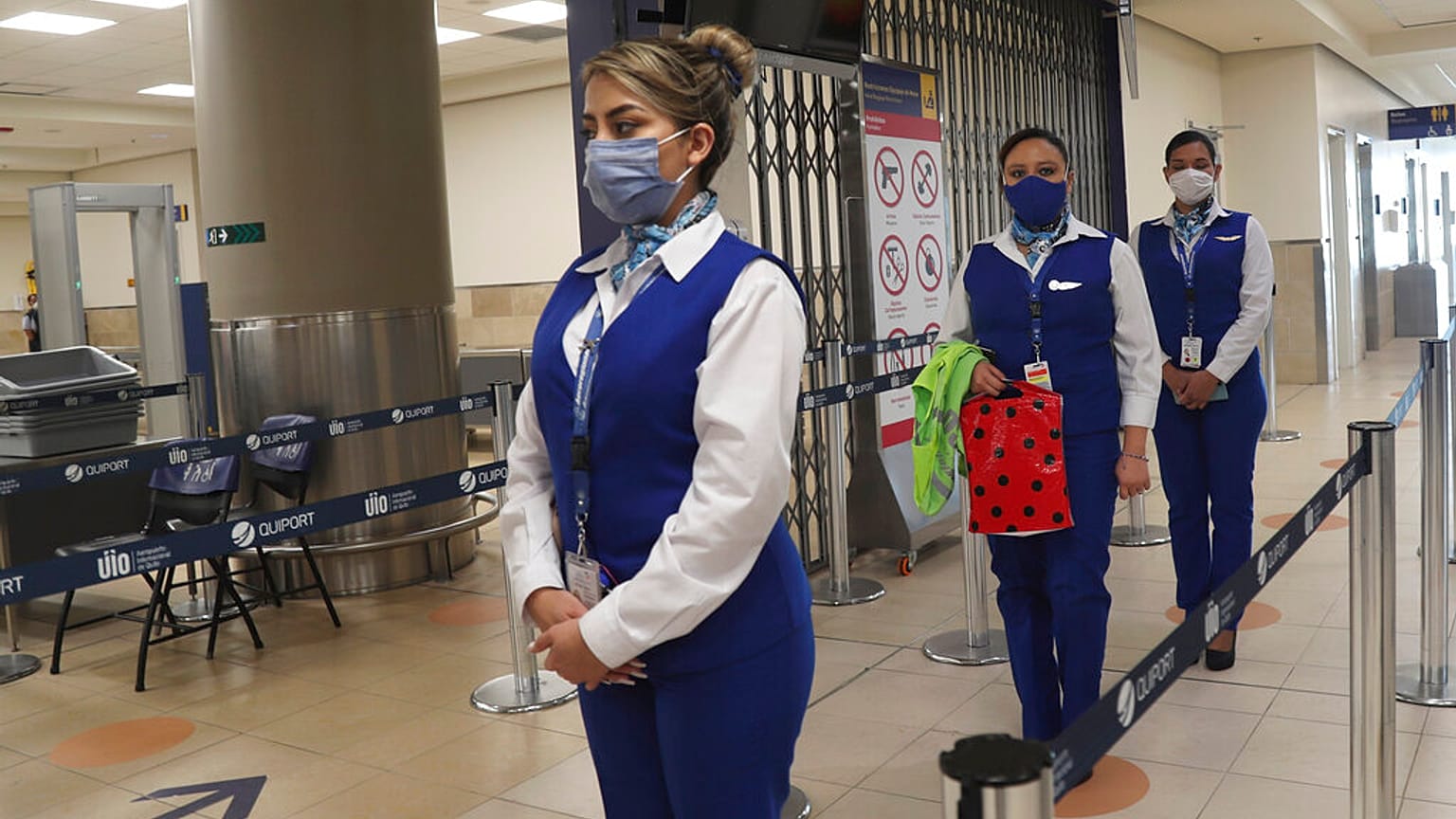 Sosyal mesafe kuralına uyan havaalanı çalışanları.