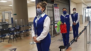 Sosyal mesafe kuralına uyan havaalanı çalışanları.