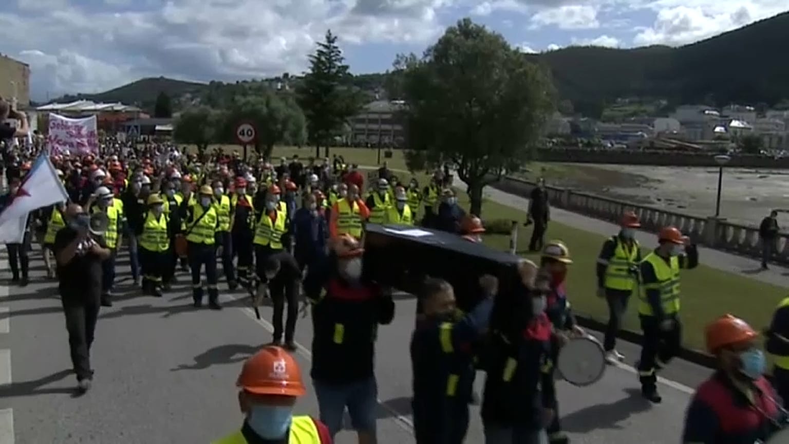 Trabajadores de Alcoa llevando el ataúd que simboliza su muerte laboral