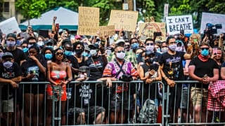 A crowd chants "Say his name" as George Floyd's casket is wheeled to a hearse after a memorial service at North Central University, Thursday, June 4, 2020, in Minneapolis.