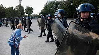An elderly woman haggles French riot police during a demonstration in Paris, France, Saturday, June 6, 2020, to protest against the recent killing of George Floyd.