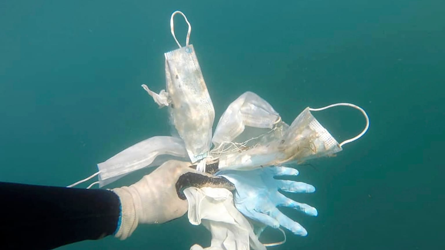 Esta foto tomada el 21 de mayo de 2020 muestra guantes de plástico y máscaras faciales y otros desechos frente a Antibes, en el sur de Francia. 