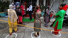 Indians queue up outside a bank to withdraw money during lockdown in Jammu, India, Tuesday, April 7, 2020. 