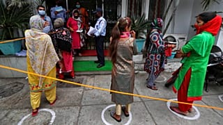 Indians queue up outside a bank to withdraw money during lockdown in Jammu, India, Tuesday, April 7, 2020. 