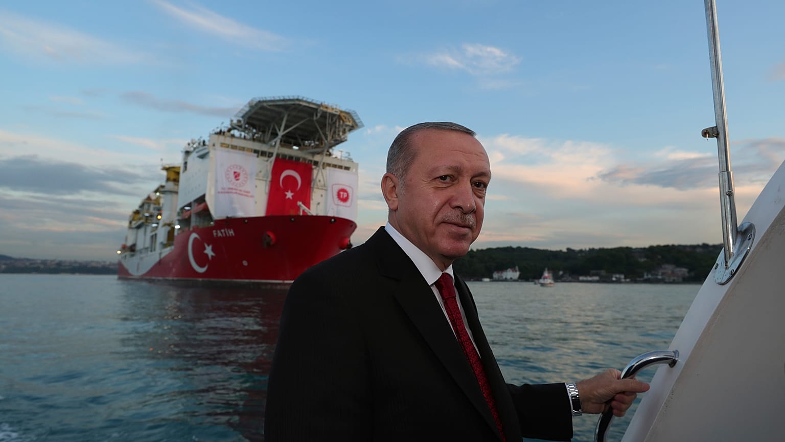 Turkey's President Recep Tayyip Erdogan, pose for photographs, backdropped by 'Fatih' 