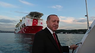 Turkey's President Recep Tayyip Erdogan, pose for photographs, backdropped by 'Fatih'