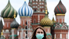 A woman wearing a protective face mask walks in front of the Saint Basil's Cathedral during the annual book fair on the Red Square in downtown Moscow on June 6, 2020