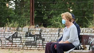 Una pareja de ancianos conversa en un banco de Madrid