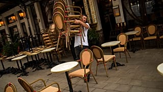 A waiter sets up a restaurant terrace during the partial lifting of coronavirus COVID-19 lockdown regulations in Brussels, June 8, 2020. (AP Photo/Francisco Seco)