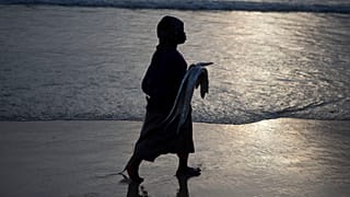 Une femme tient un poisson sur la plage de saint-Louis, Sénégal, le 18 mai 2013