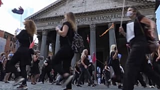 Tour Guide protesters dressed in black in front of the Pantheon, clapping hands and banging lids
