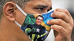 Brezilya Başkanı Jair Bolsonaro resimli maske takan bir kişi