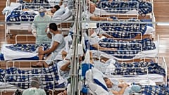 COVID-19 patients lie on beds in a field hospital built inside a gym in Santo Andre