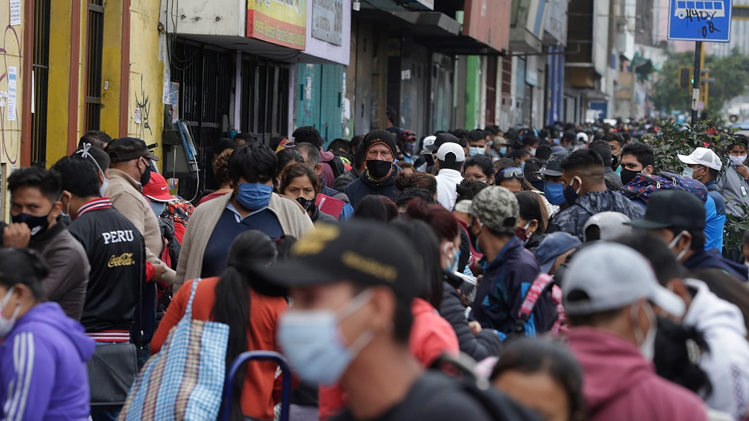Cientos de personas, vendendores ambulantes, compradores y transeúntes, abarrotan una calle en Lima