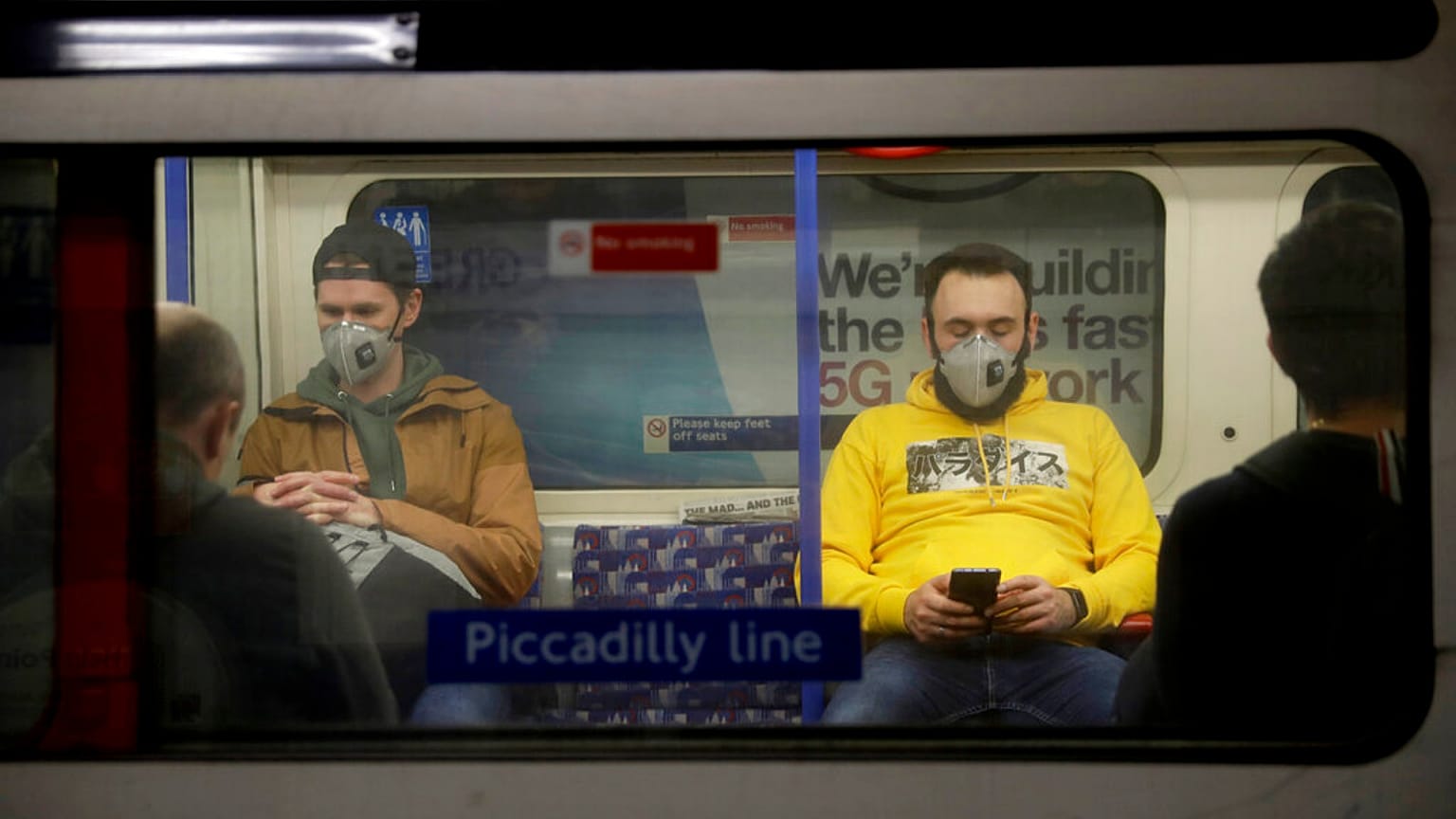 Passengers wearing face masks travel on a Piccadilly Line underground train in London, March 20, 2020 (file).