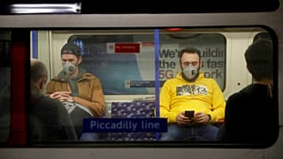 Passengers wearing face masks travel on a Piccadilly Line underground train in London, March 20, 2020 (file).
