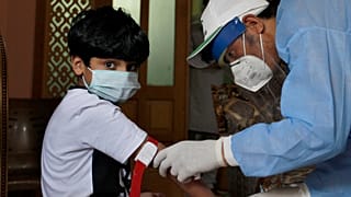 Criança realiza teste de sangue para despistar o novo coronavírus no Paquistão