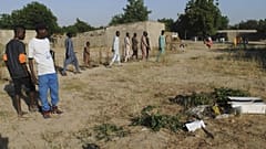 People gathered at the site of a suicide attack in Maiduguri, Nigeria, Thursday, Nov. 16, 2017.