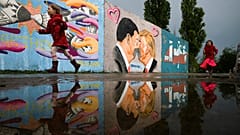 Graffiti depicts U.S. President Trump, right, and China's President Xi Jinping kissing each other with face masks on a wall in Berlin